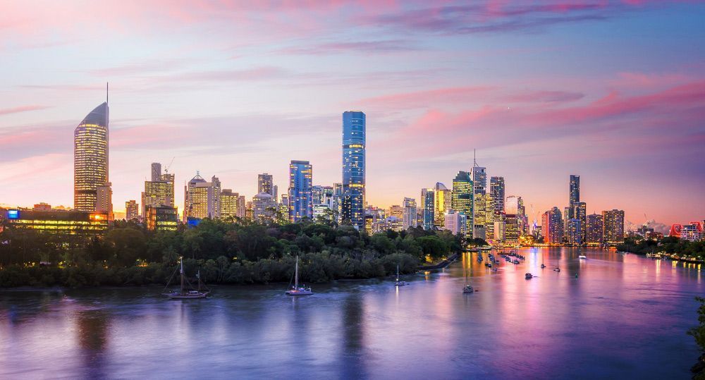 A City Skyline Over a Body of Water at Sunset — Beards Roofing and Plumbing in Brisbane, QLD
