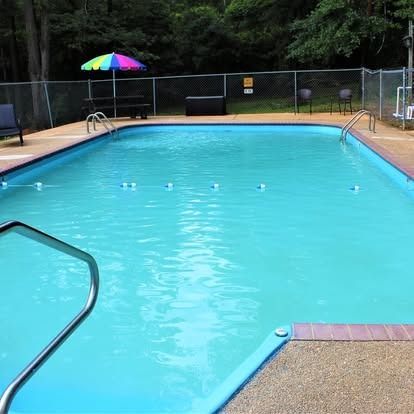 A large swimming pool with a colorful umbrella in the background