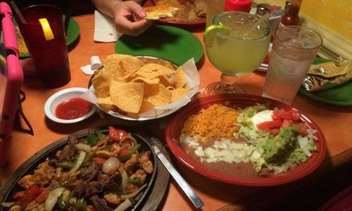 A table topped with plates of food and drinks.
