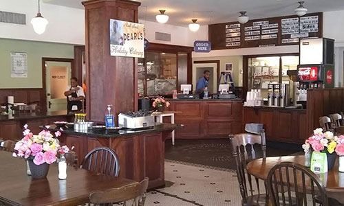 A restaurant with tables and chairs and a sign that says coffee