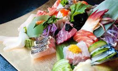 A close up of a plate of sushi on a table.