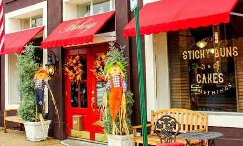 A store front with a sign that says sticky buns and cakes