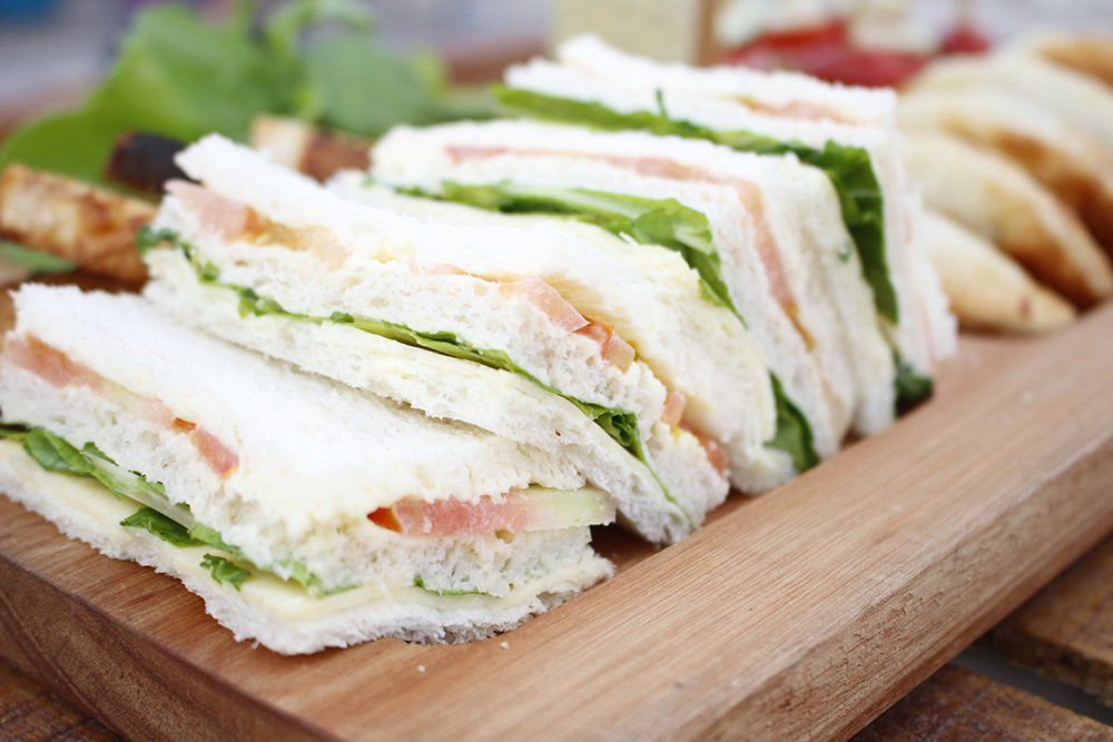 Sándwiches de lechuga y salmón servidos en una tabla de madera.