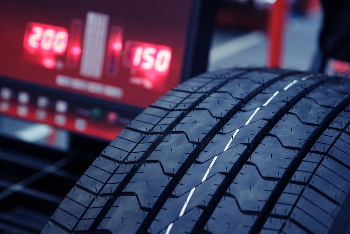 A close up of a tire being balanced on a machine.