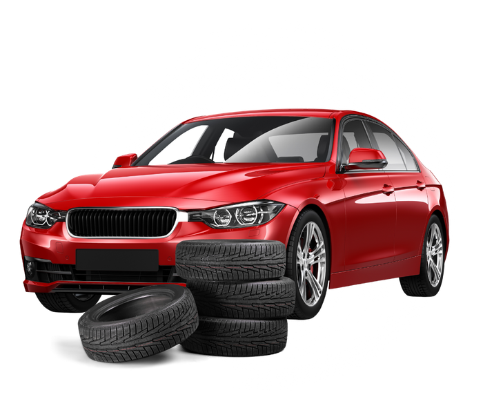 A red car is sitting on top of a pile of tires.