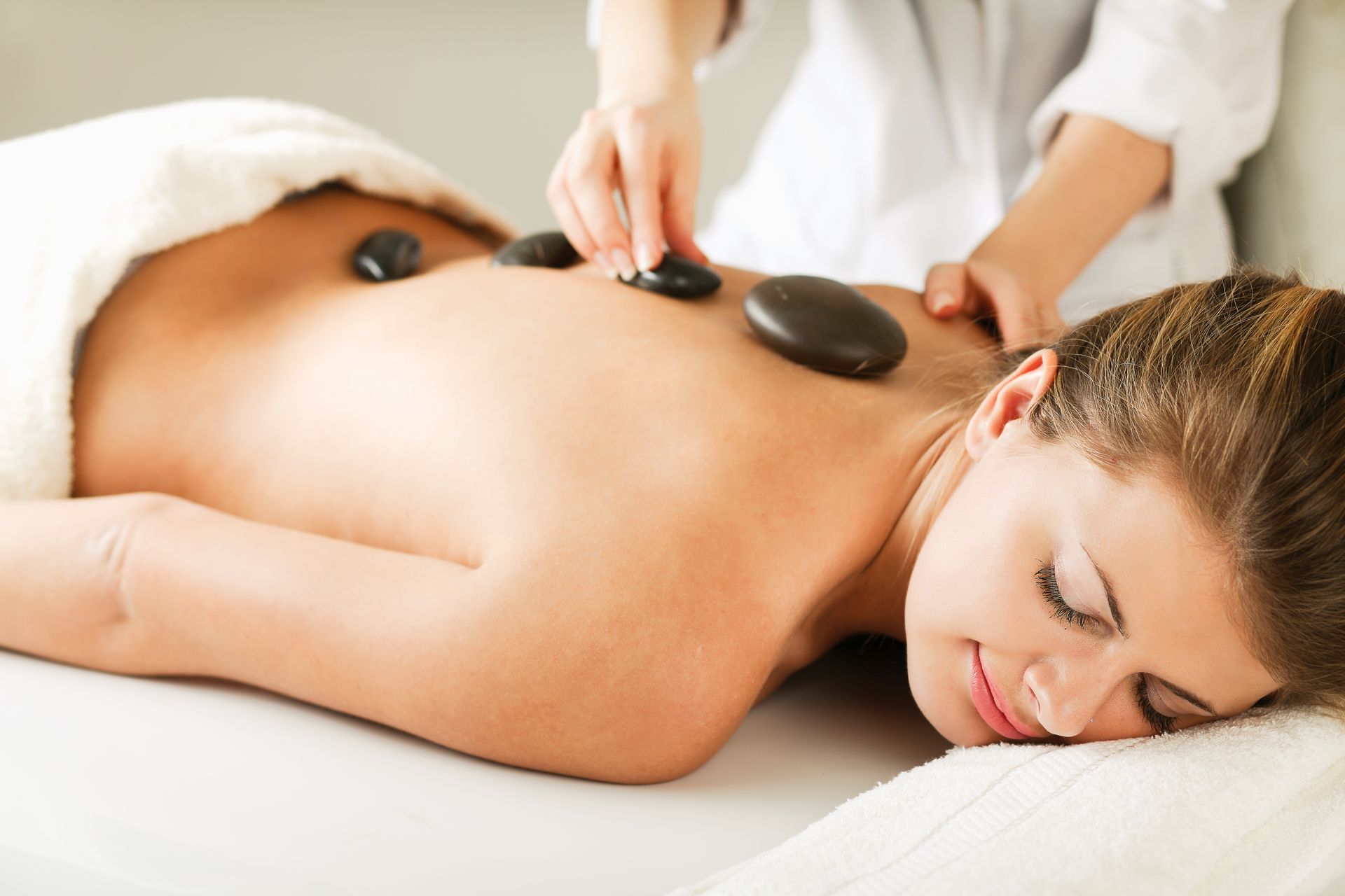 A woman is getting a hot stone massage at a spa.