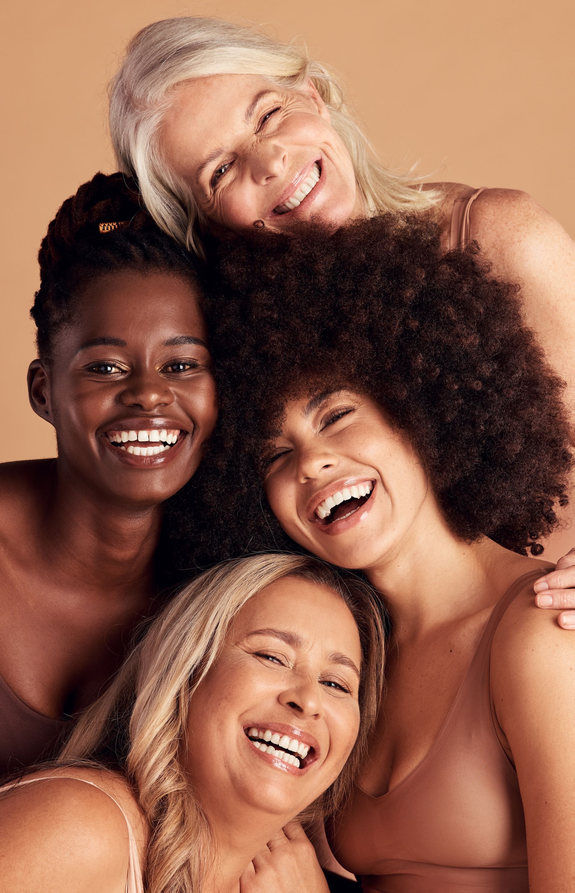 A group of women are posing for a picture together and smiling.