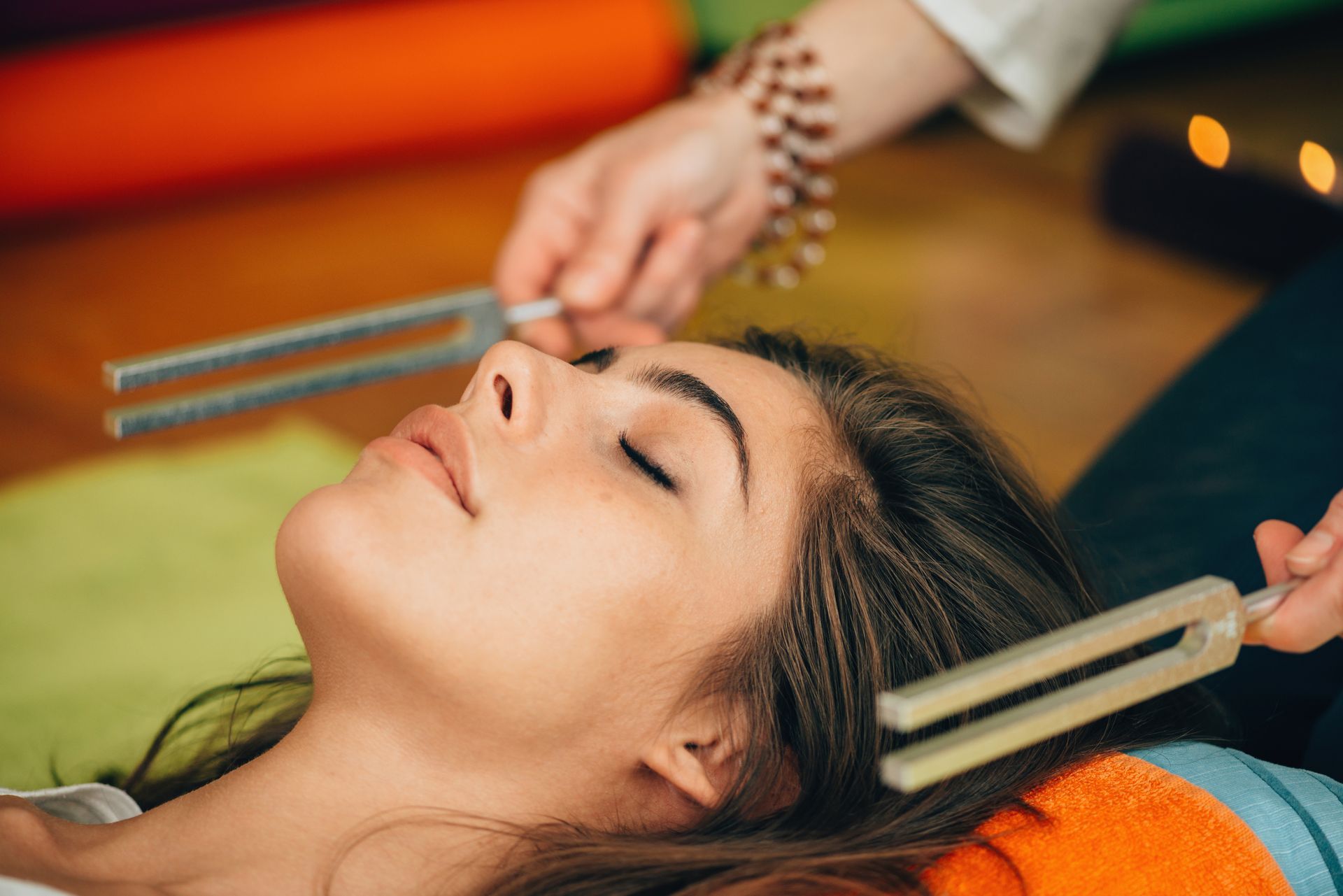 A woman is laying on the floor getting a massage with a fork.