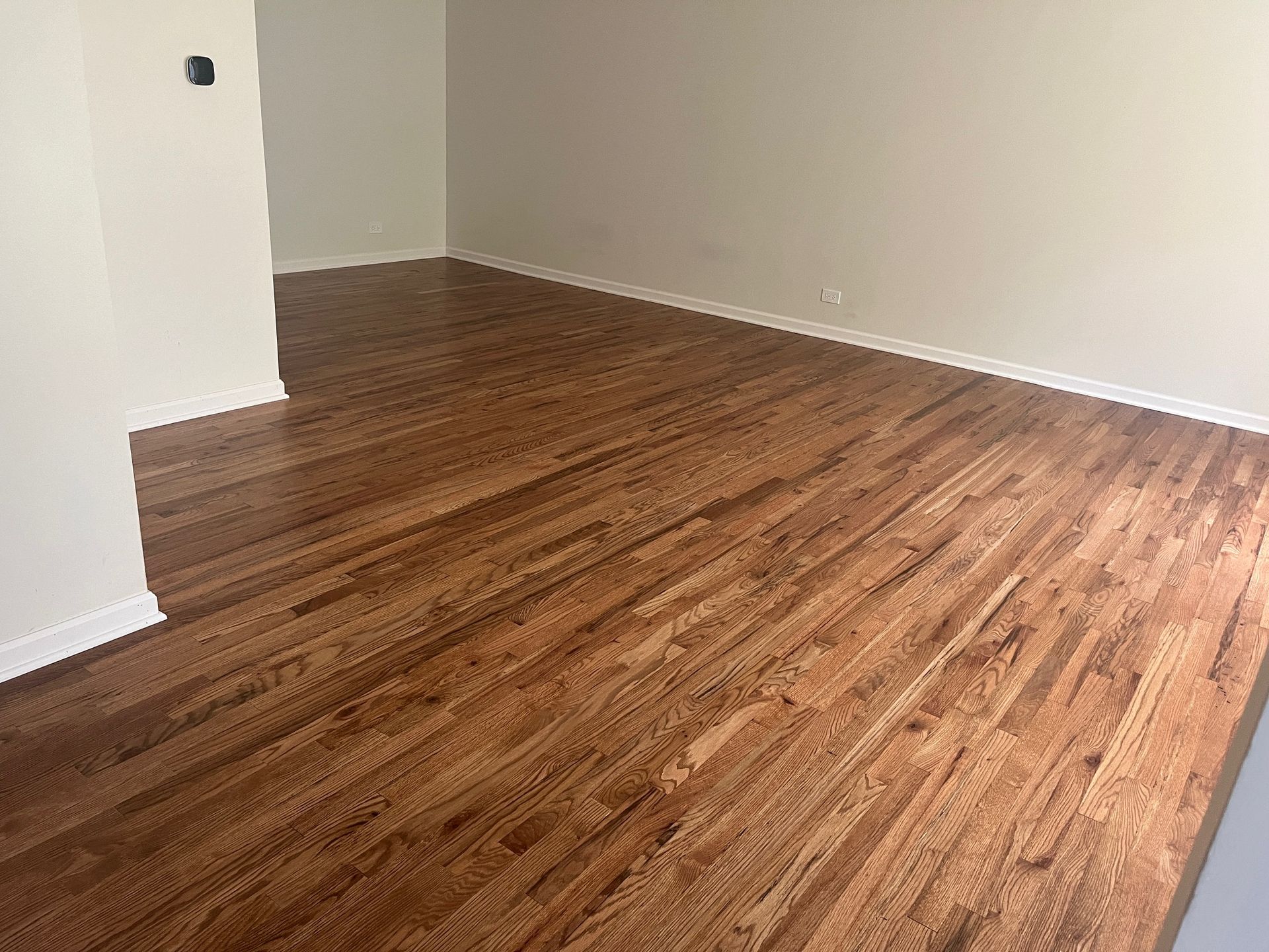 A living room with hardwood floors and white walls.