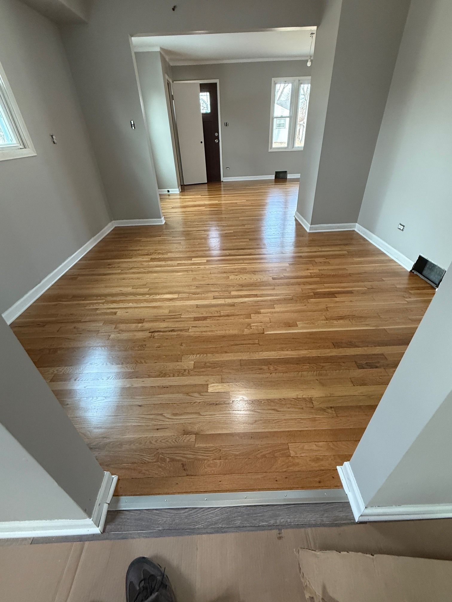 A living room with hardwood floors and gray walls.
