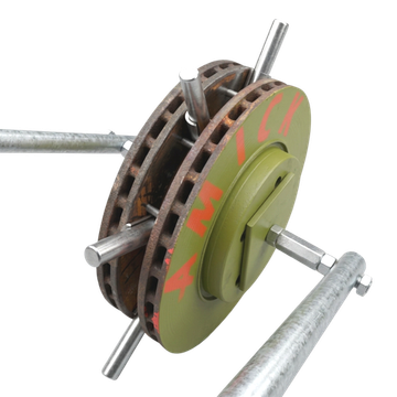 A rusty, vented brake disc painted olive green, mounted on a metal frame with four extending steel rods.