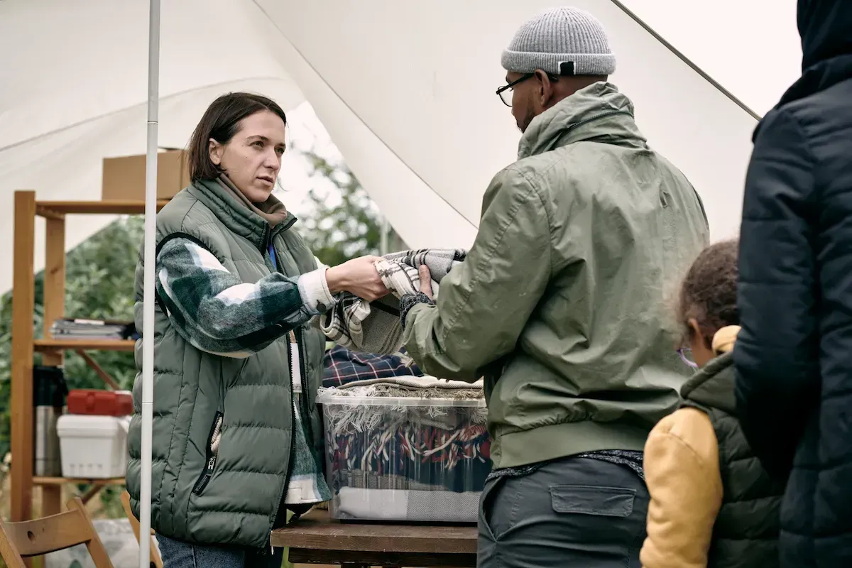 Social worker providing warm plaids to refugees