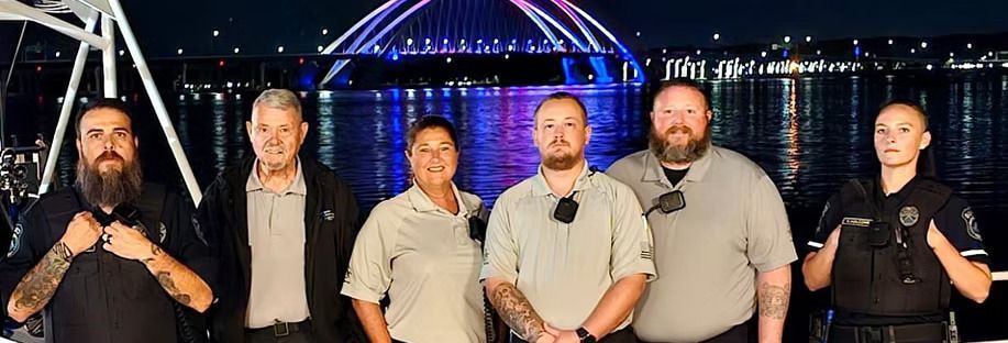 A group of people standing next to each other in front of a bridge.