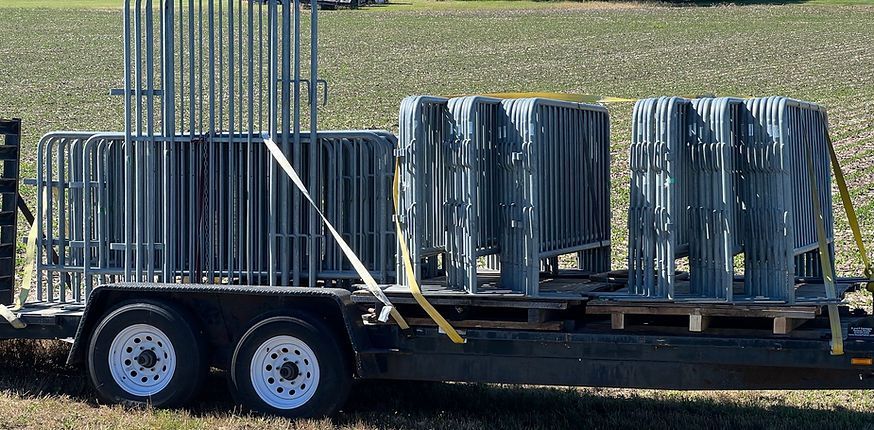 A trailer with a bunch of fences on it is parked in a field.