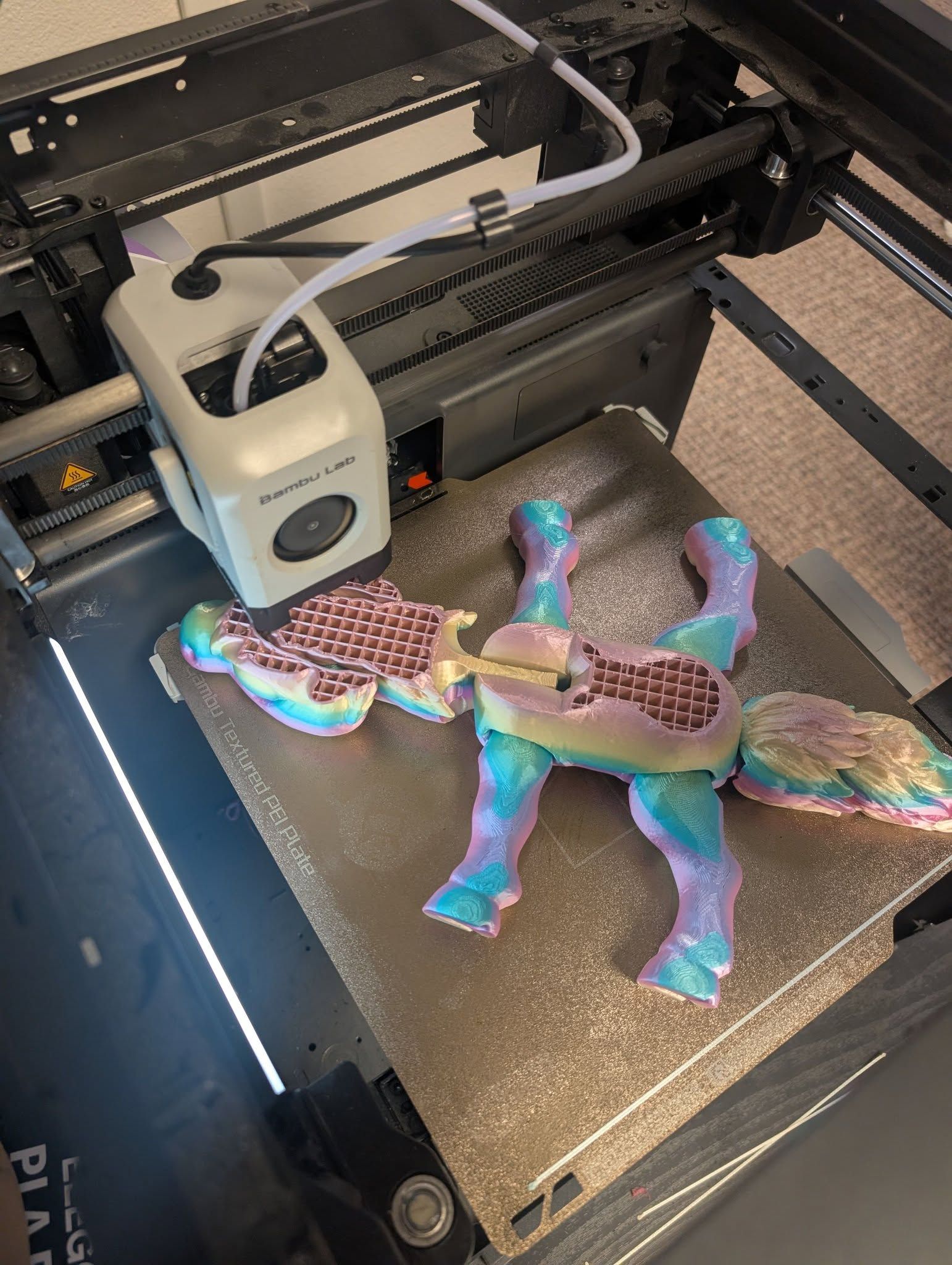 3D printer printing a colorful camel figurine on the build plate