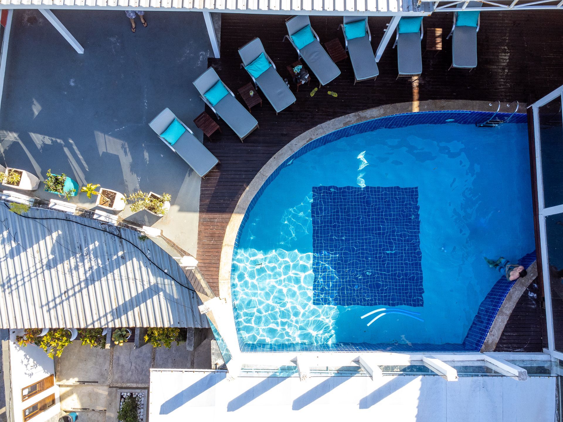 Uma vista aérea de uma piscina com cadeiras ao redor