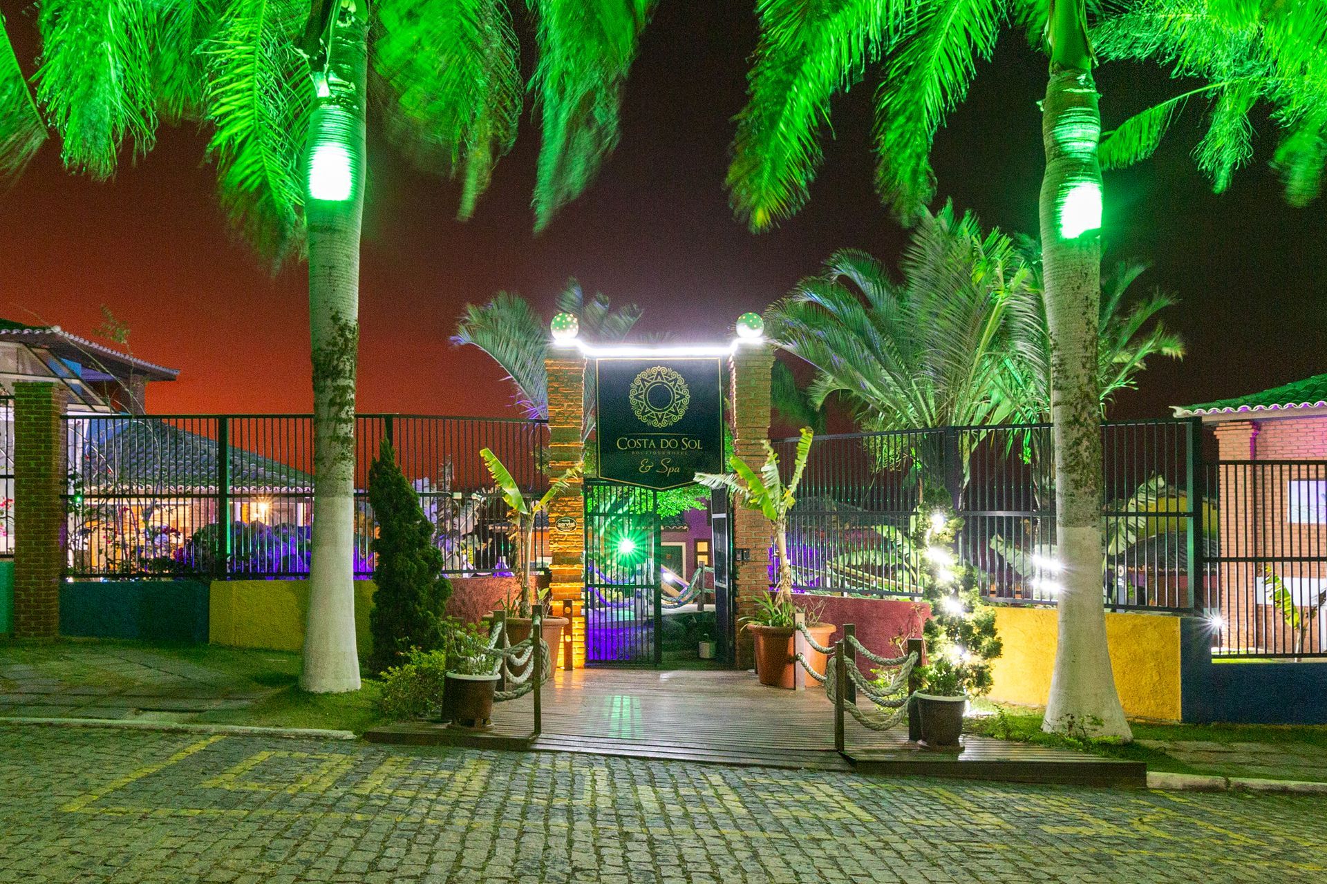 Um prédio com palmeiras na frente à noite