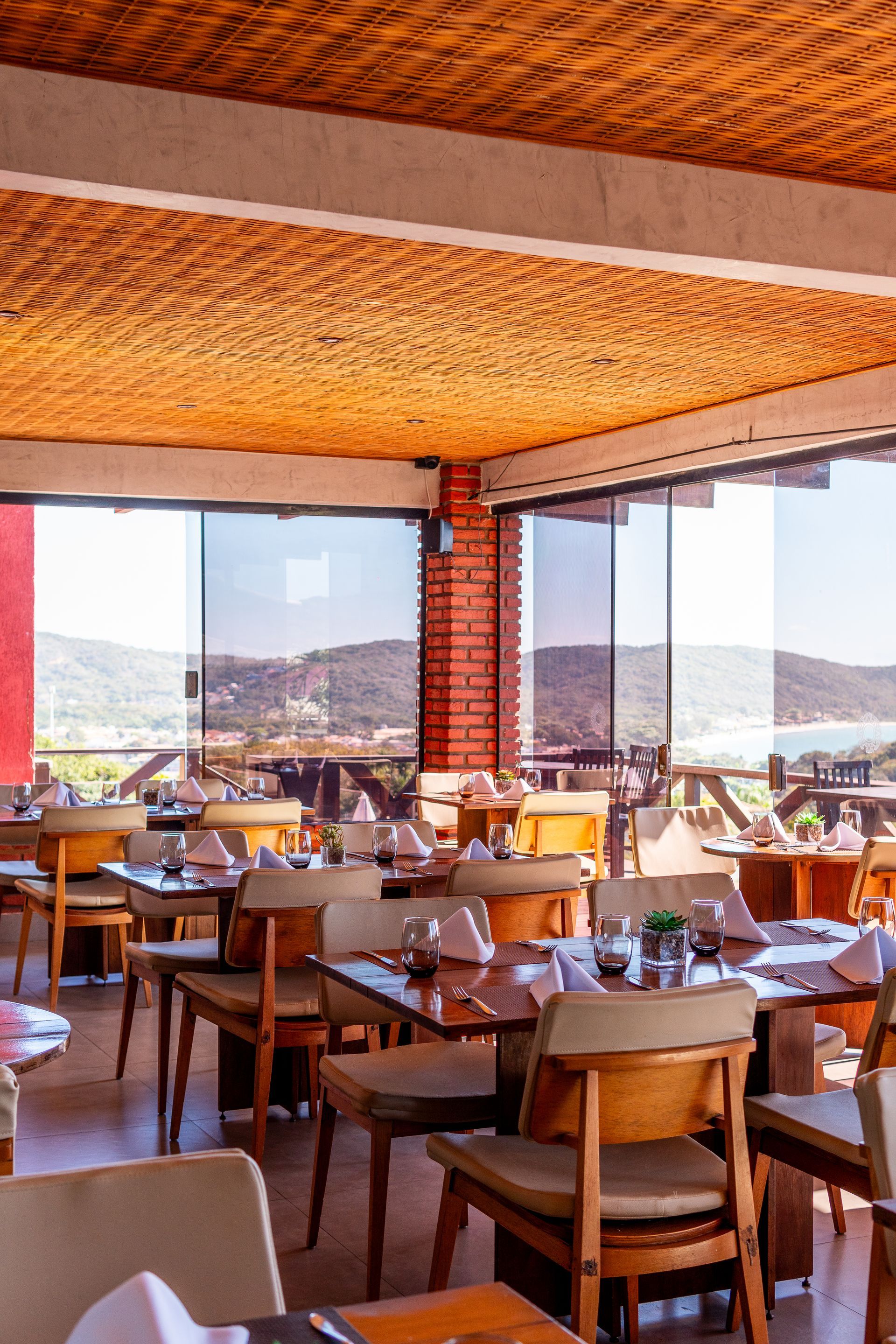 Um restaurante com mesas e cadeiras e uma grande janela