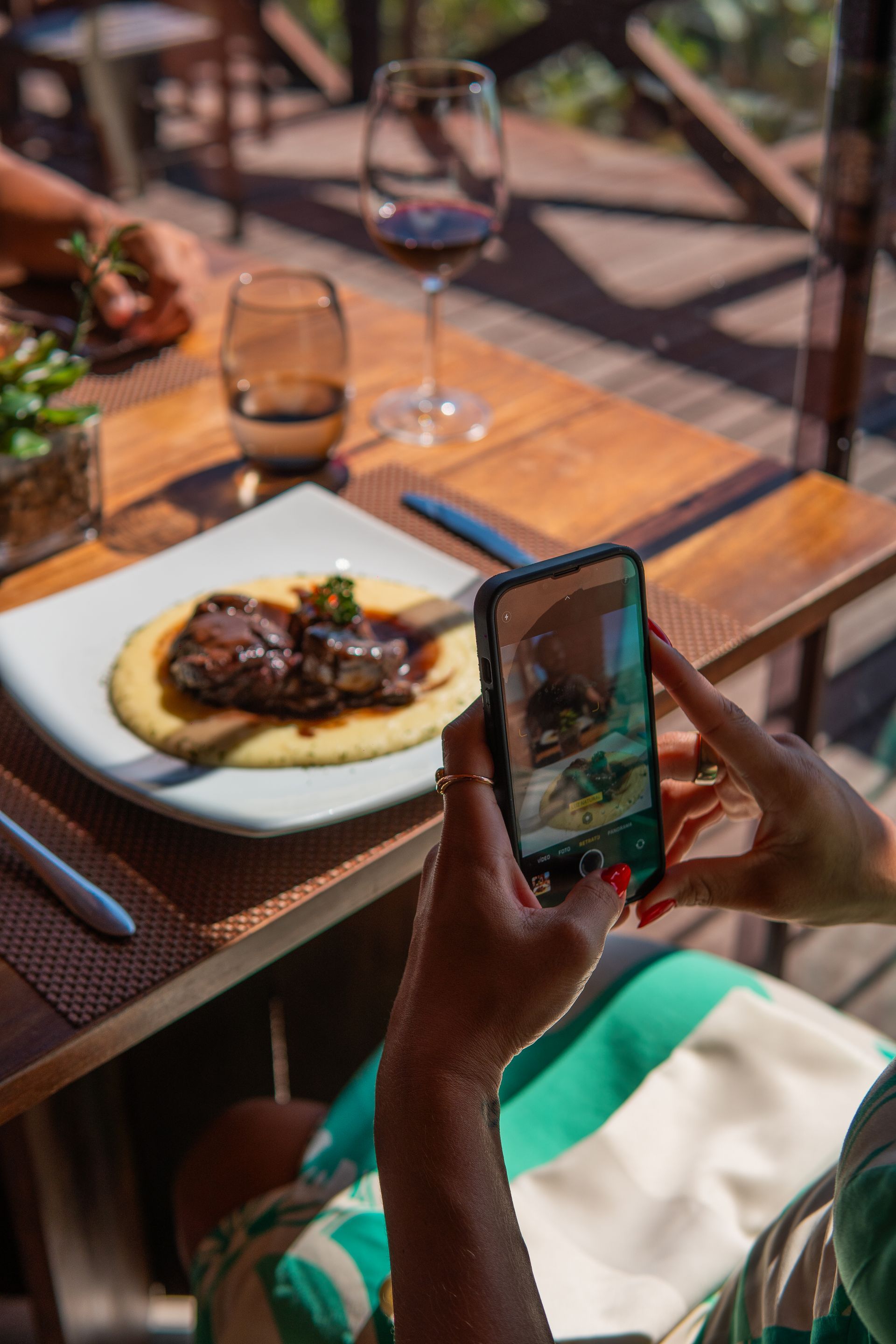 Uma pessoa está tirando uma foto de um prato de comida com um celular.