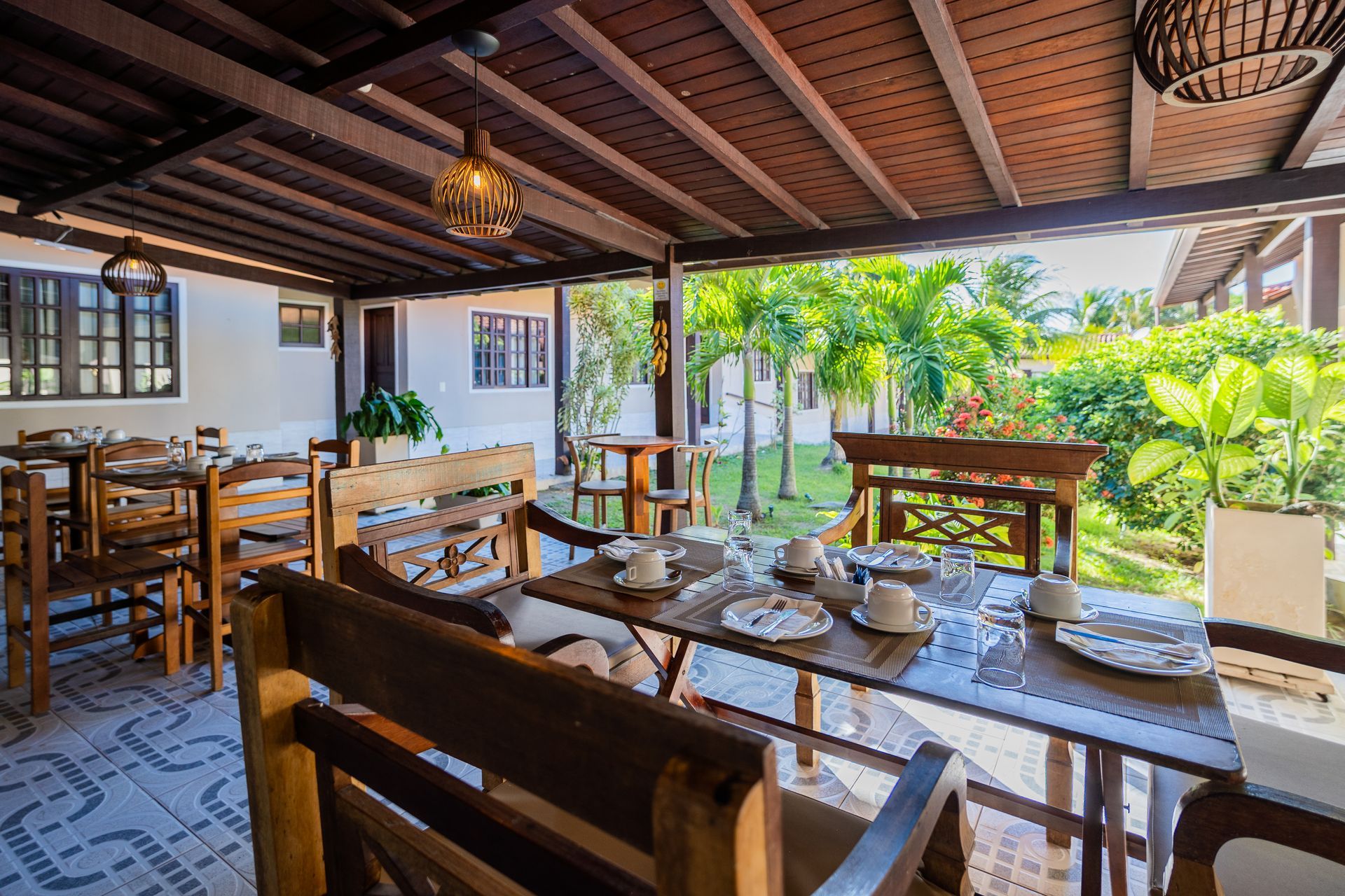 Um restaurante com mesas e cadeiras sob um toldo.