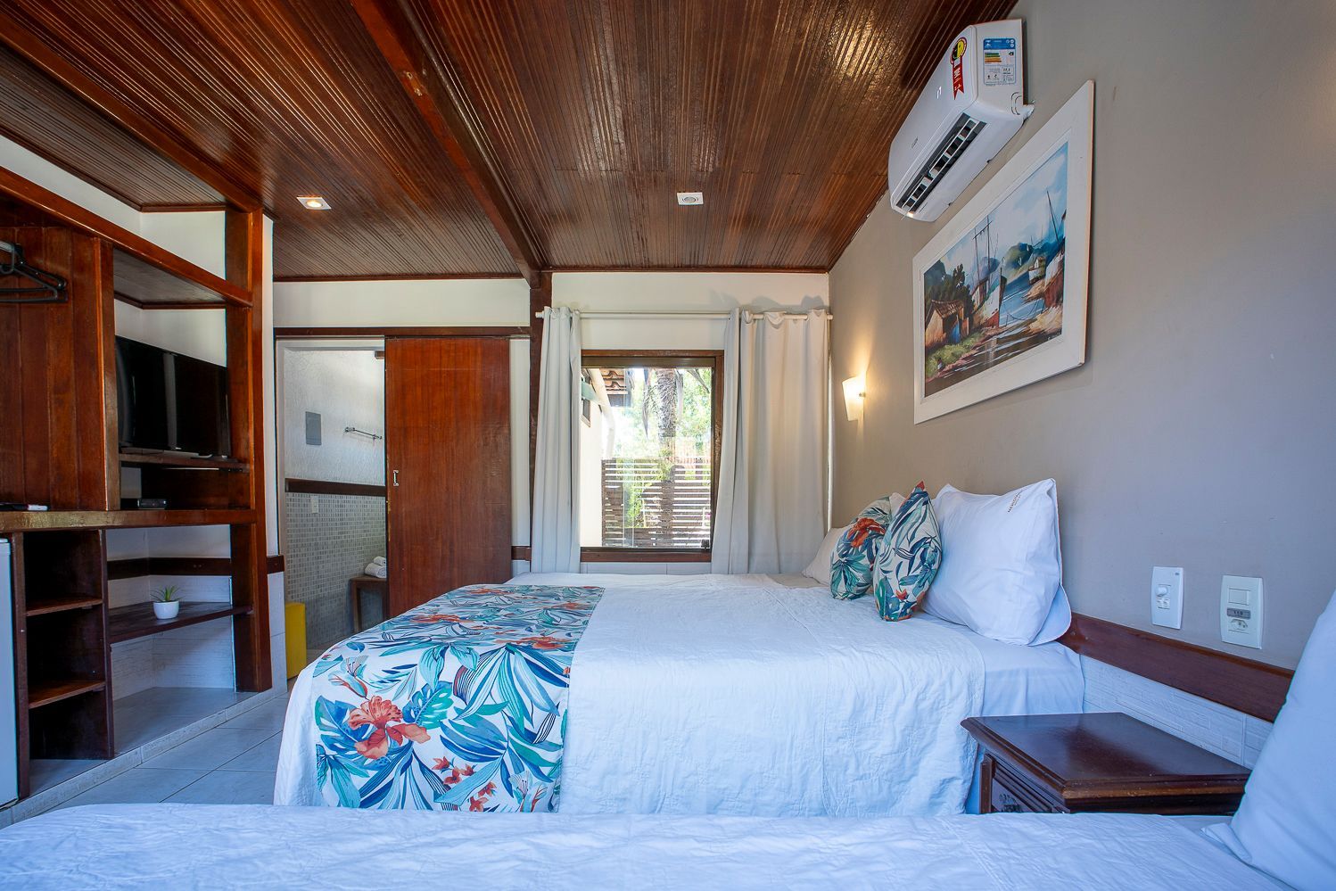 Um quarto de hotel com duas camas e um quadro na parede.