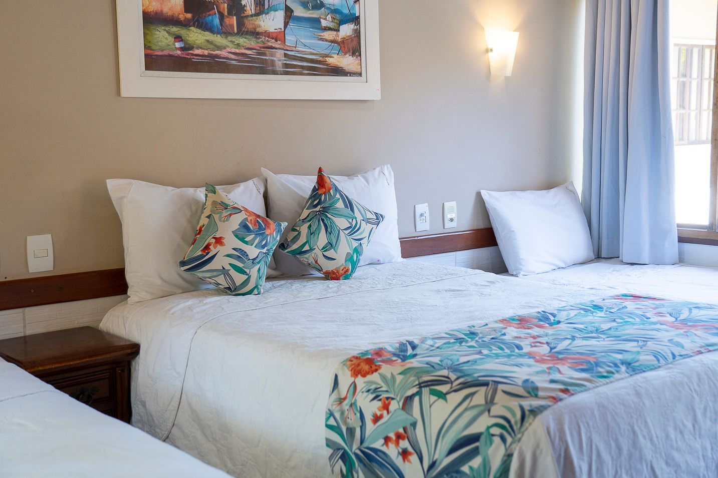 Um quarto de hotel com duas camas e uma pintura na parede.