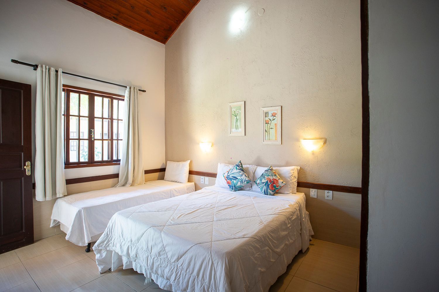 Um quarto com duas camas e uma janela.