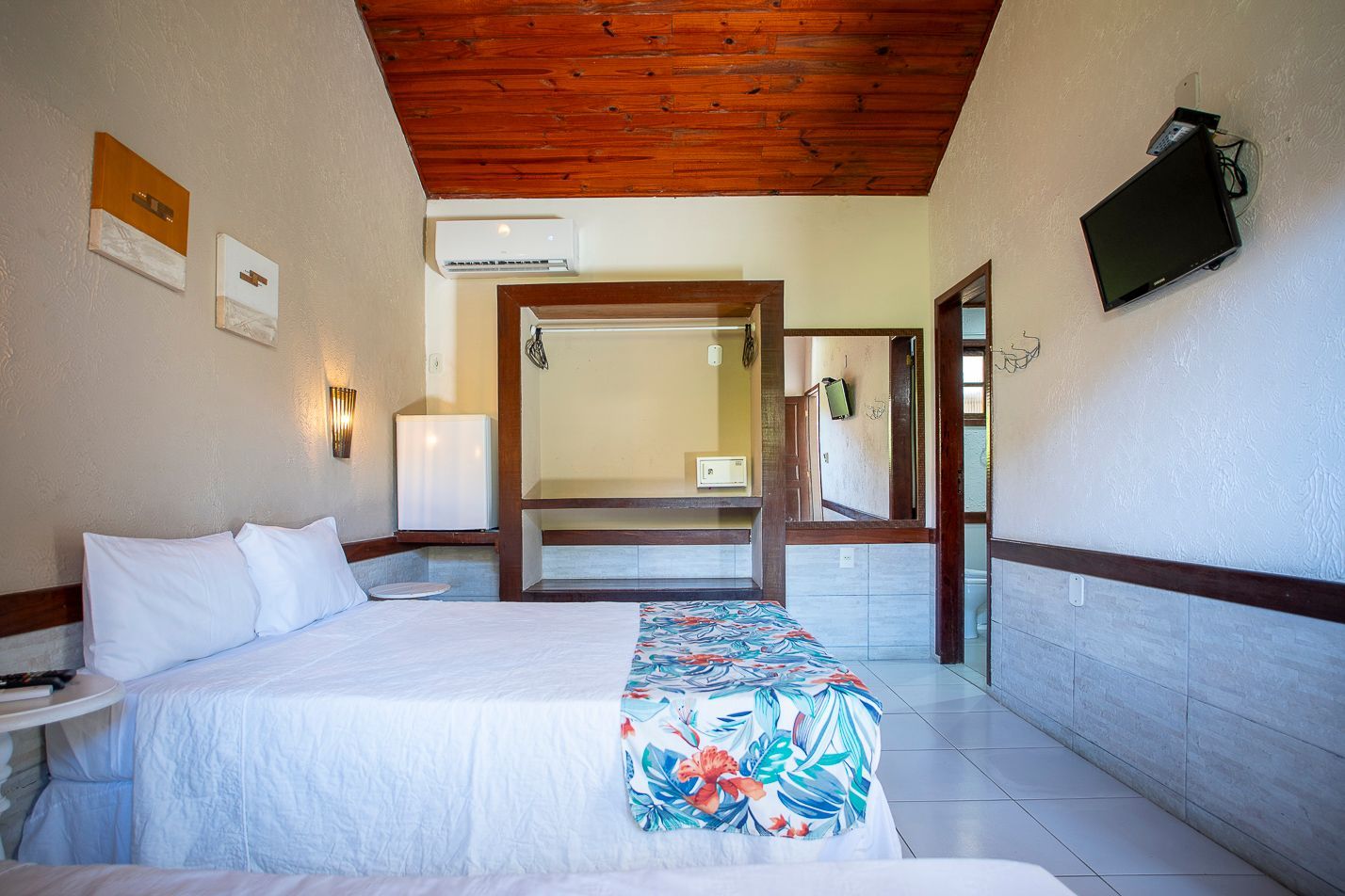 Um quarto de hotel com duas camas e uma TV de tela plana.