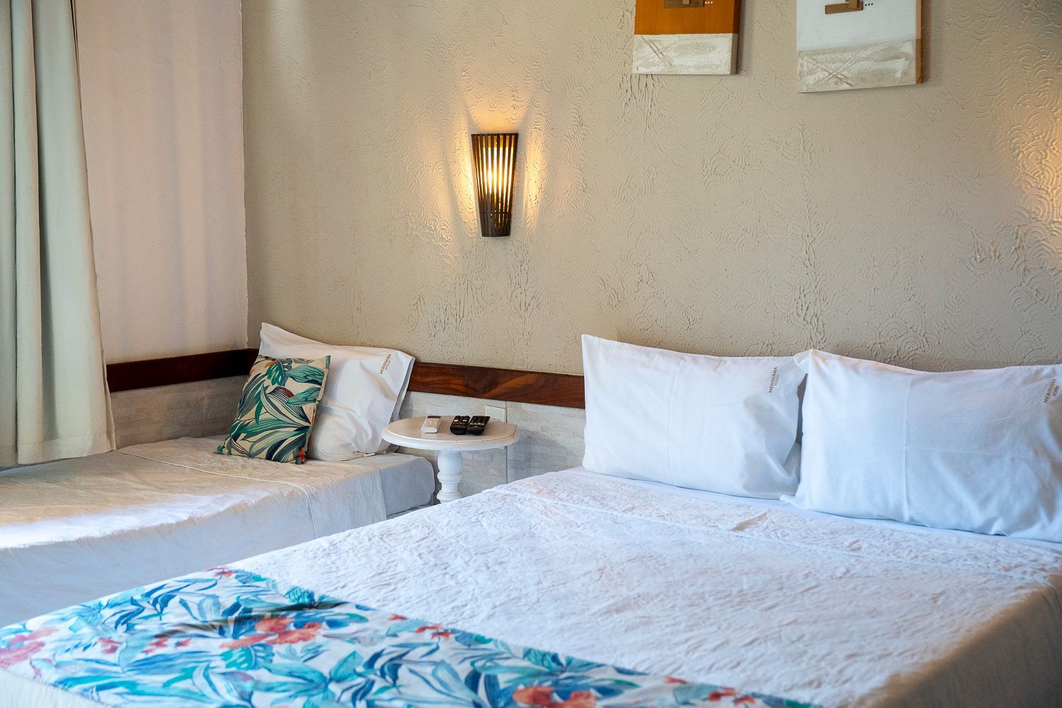 Um quarto de hotel com duas camas e uma mesa.