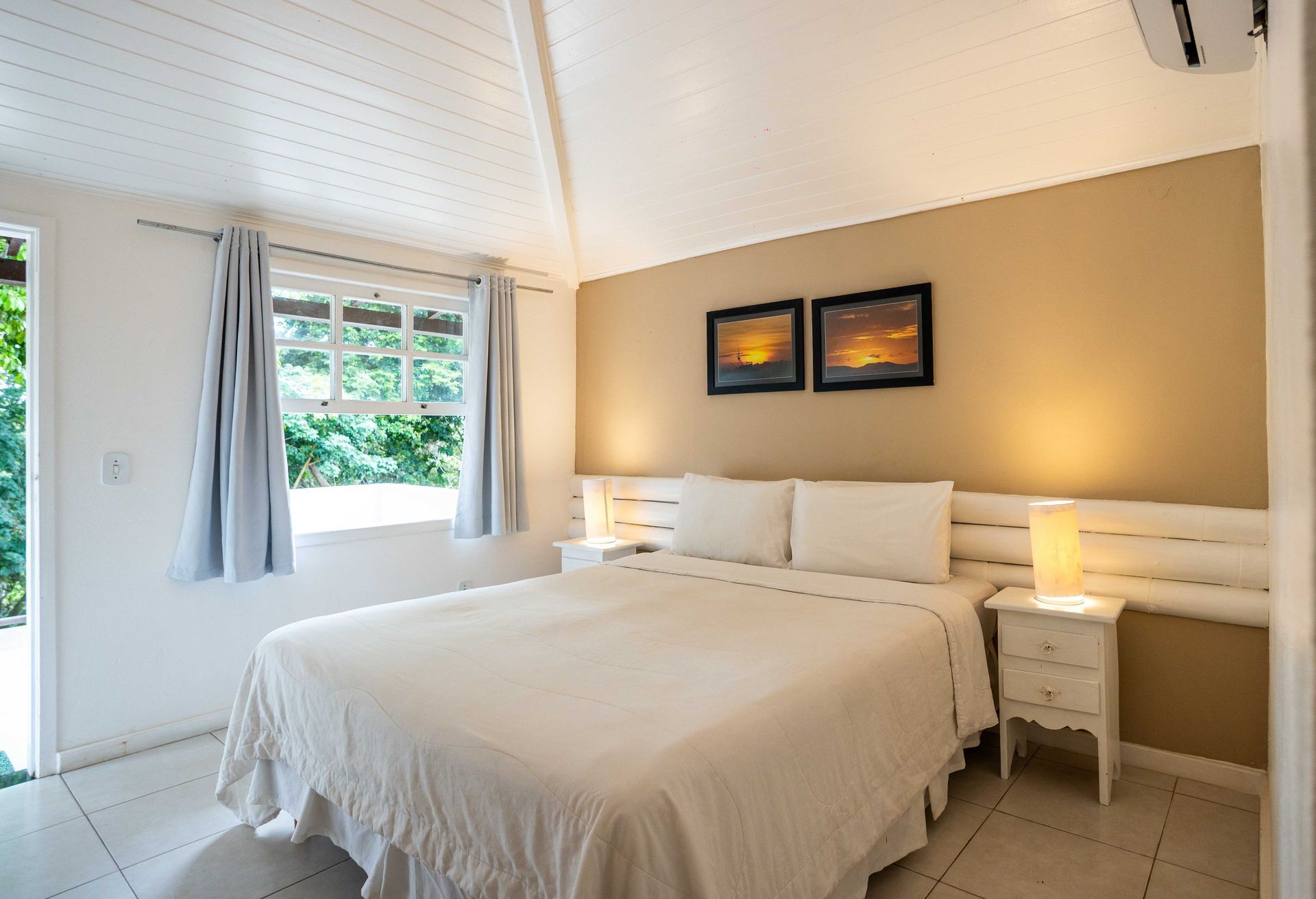 Um quarto com uma cama king size e duas mesas de cabeceira.