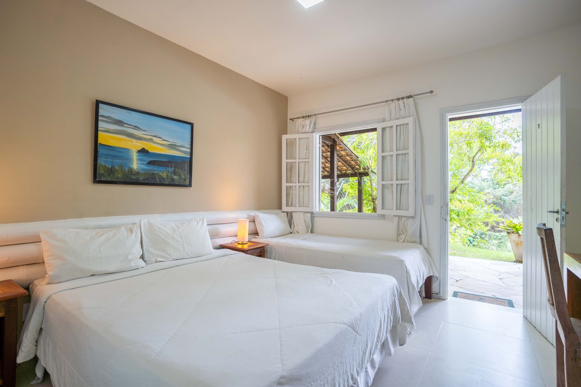 Um quarto de hotel com duas camas e um quadro na parede.
