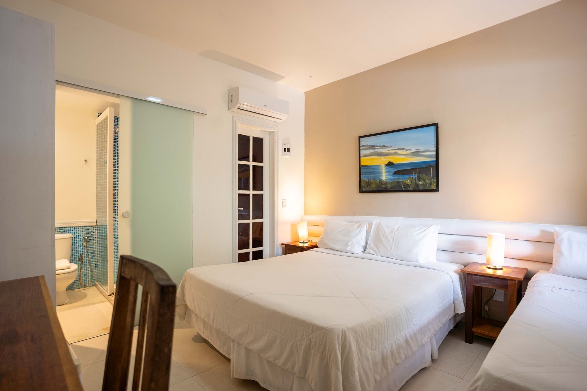 Um quarto de pousada com uma cama king size e uma cama de solteiro.