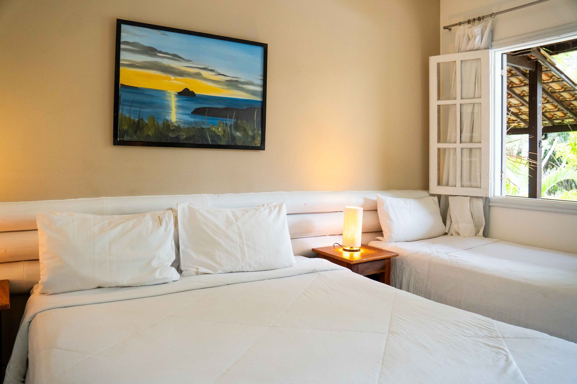 Quarto com cama king size com um quadro acima da cama 