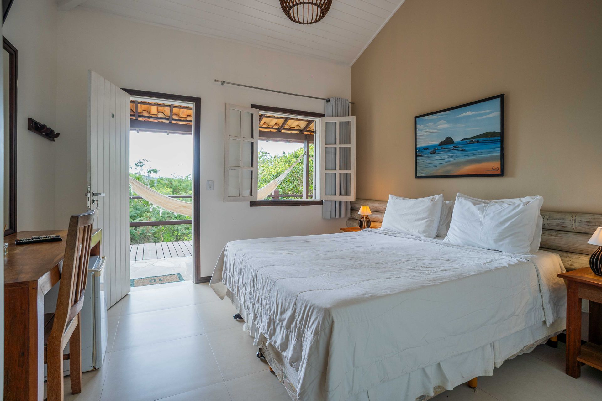 Um quarto com uma cama grande e um quadro na parede.