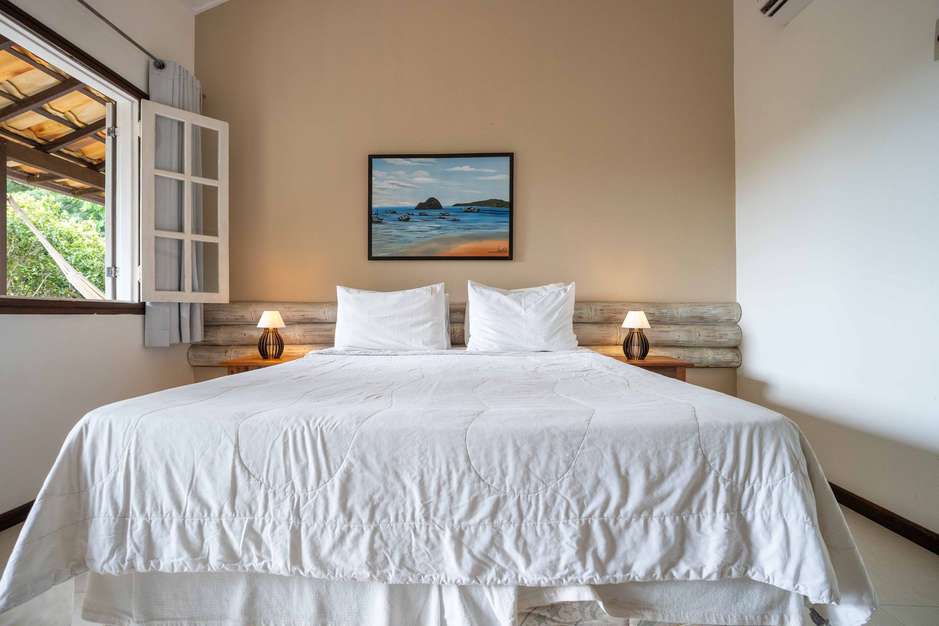 Um quarto com uma cama grande e um quadro na parede acima dela.
