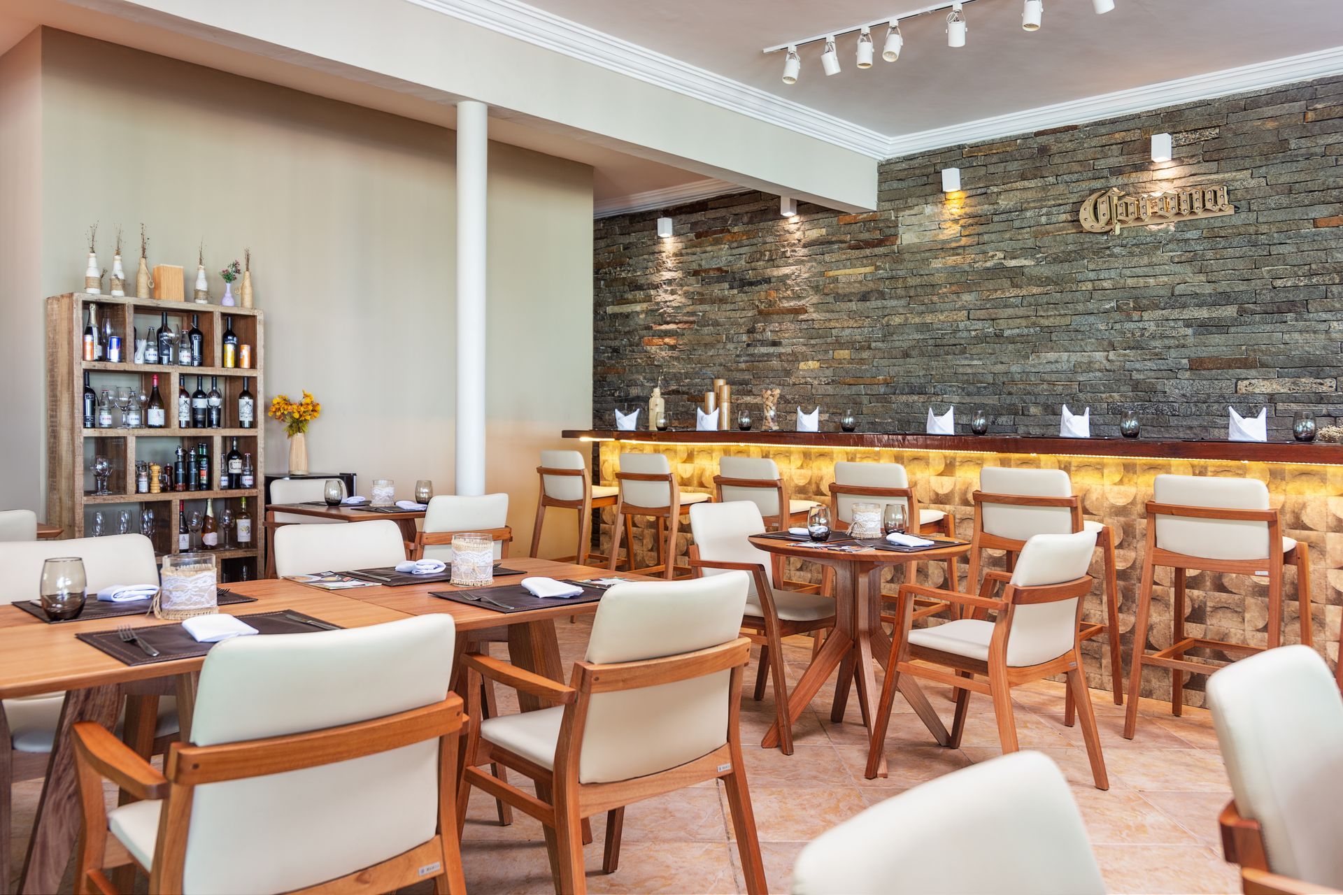 Um restaurante com mesas e cadeiras e um bar.