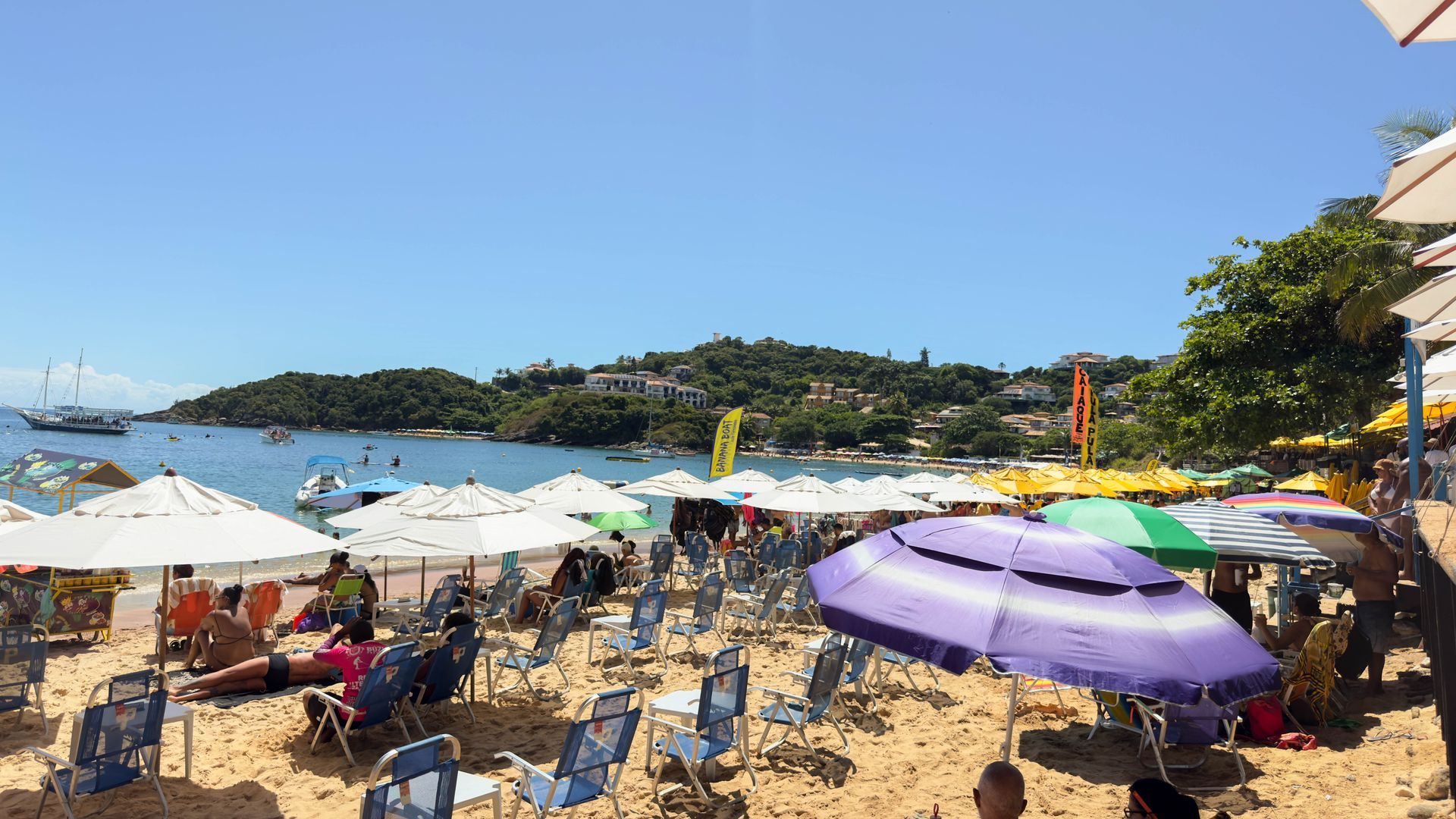 Uma praia cheia de cadeiras e guarda-sóis em um dia ensolarado.