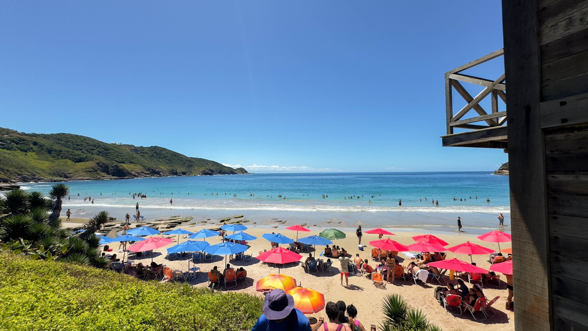 Uma praia com muitas pessoas e guarda-sóis