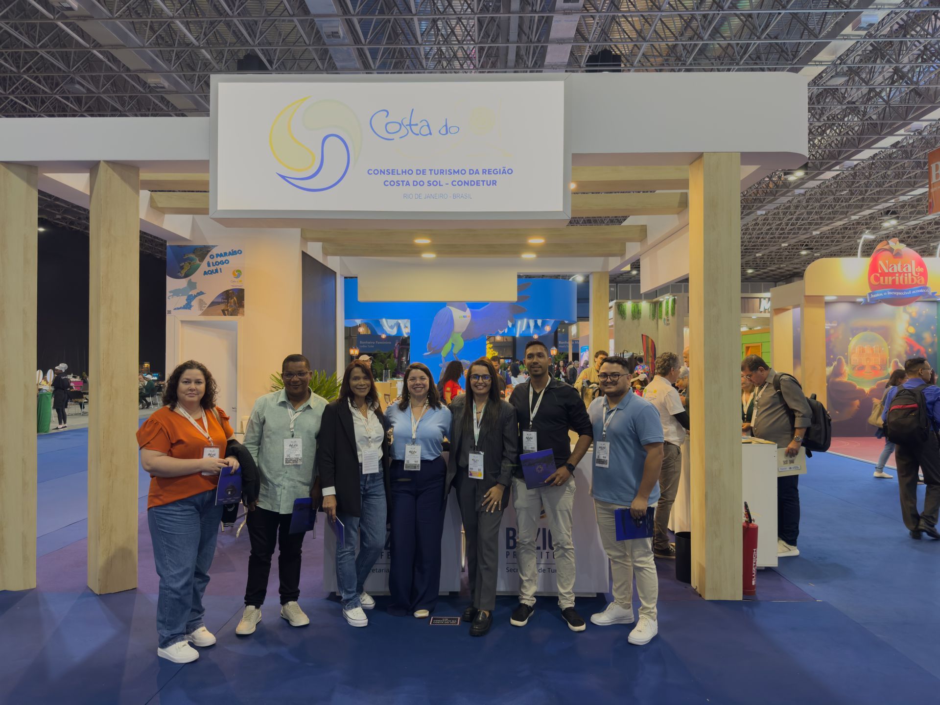 Group of people posing under a sign for 