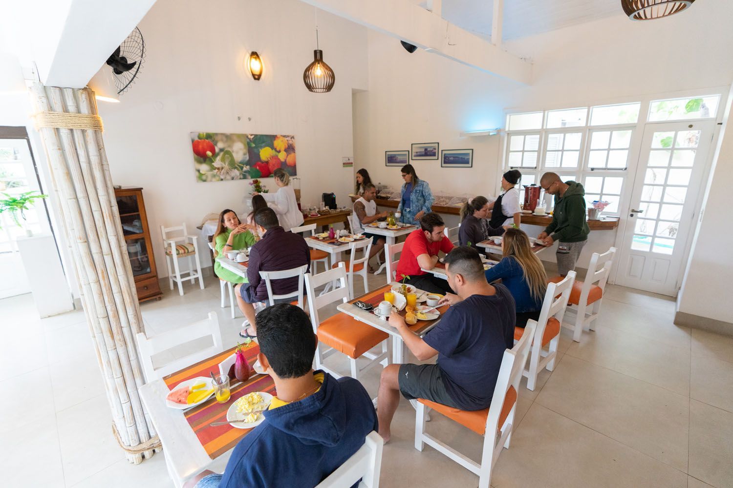 Um grupo de pessoas está sentado à mesa em um restaurante comendo.