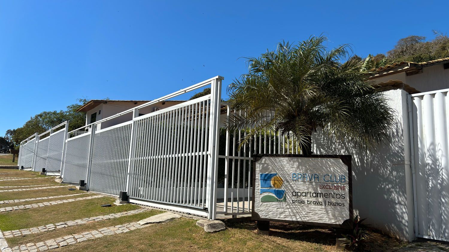 Uma cerca branca com uma placa na frente