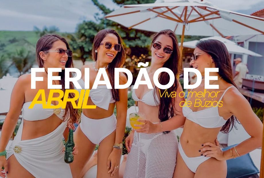 Quatro pessoas em trajes de banho brancos sorriem juntas ao ar livre sob um guarda-chuva, com um texto que promove férias em abril em Búzios.