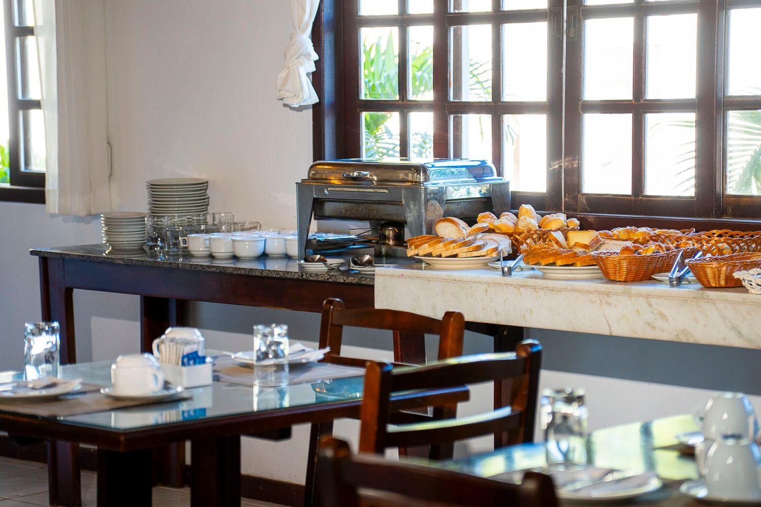 Um restaurante com mesas e cadeiras e um bufê
