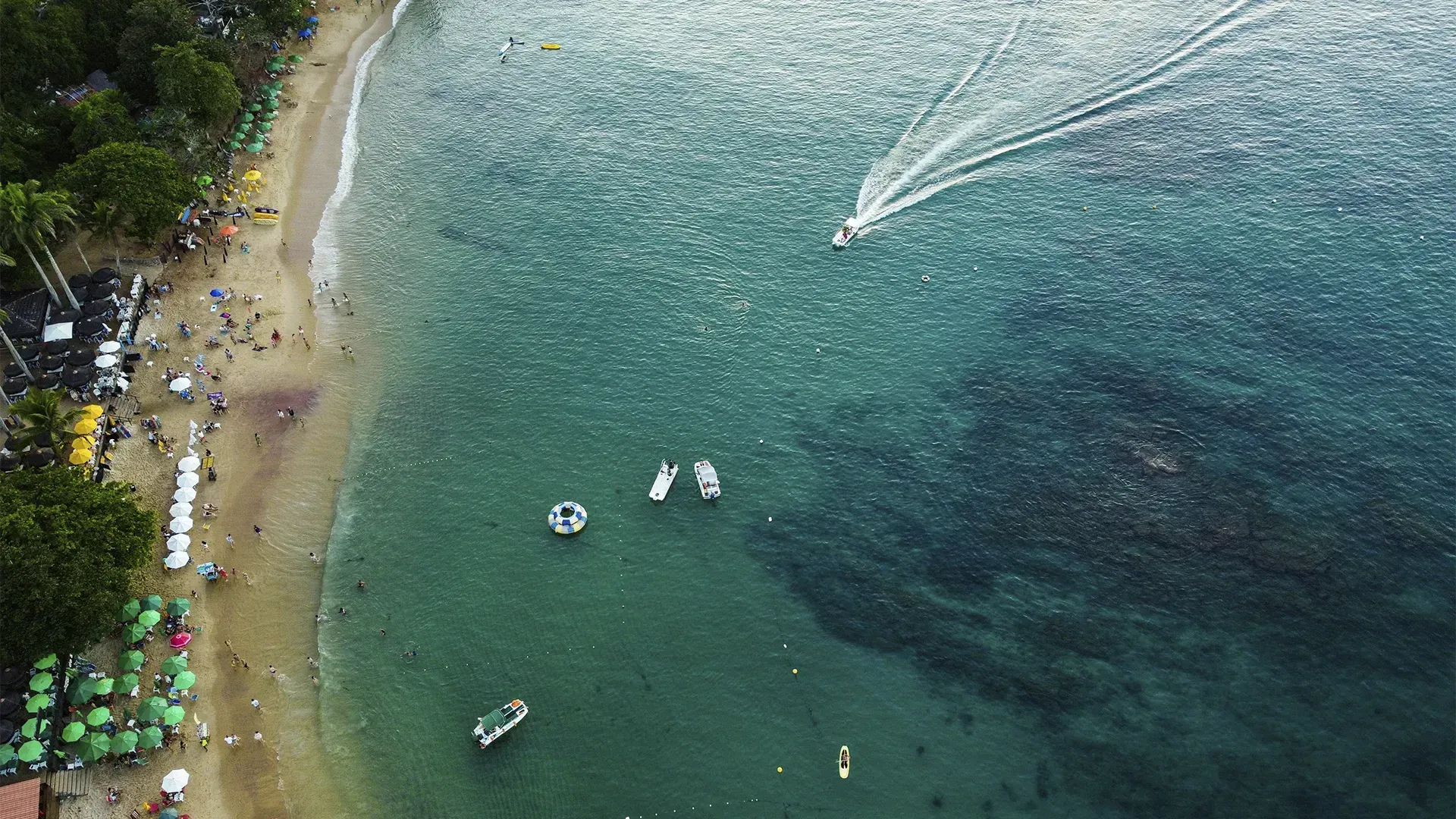 Uma vista aérea de uma praia com barcos na água.