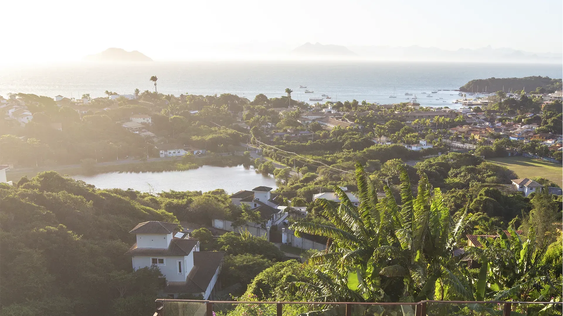 Uma vista de uma cidade de uma varanda com vista para um lago e o oceano.