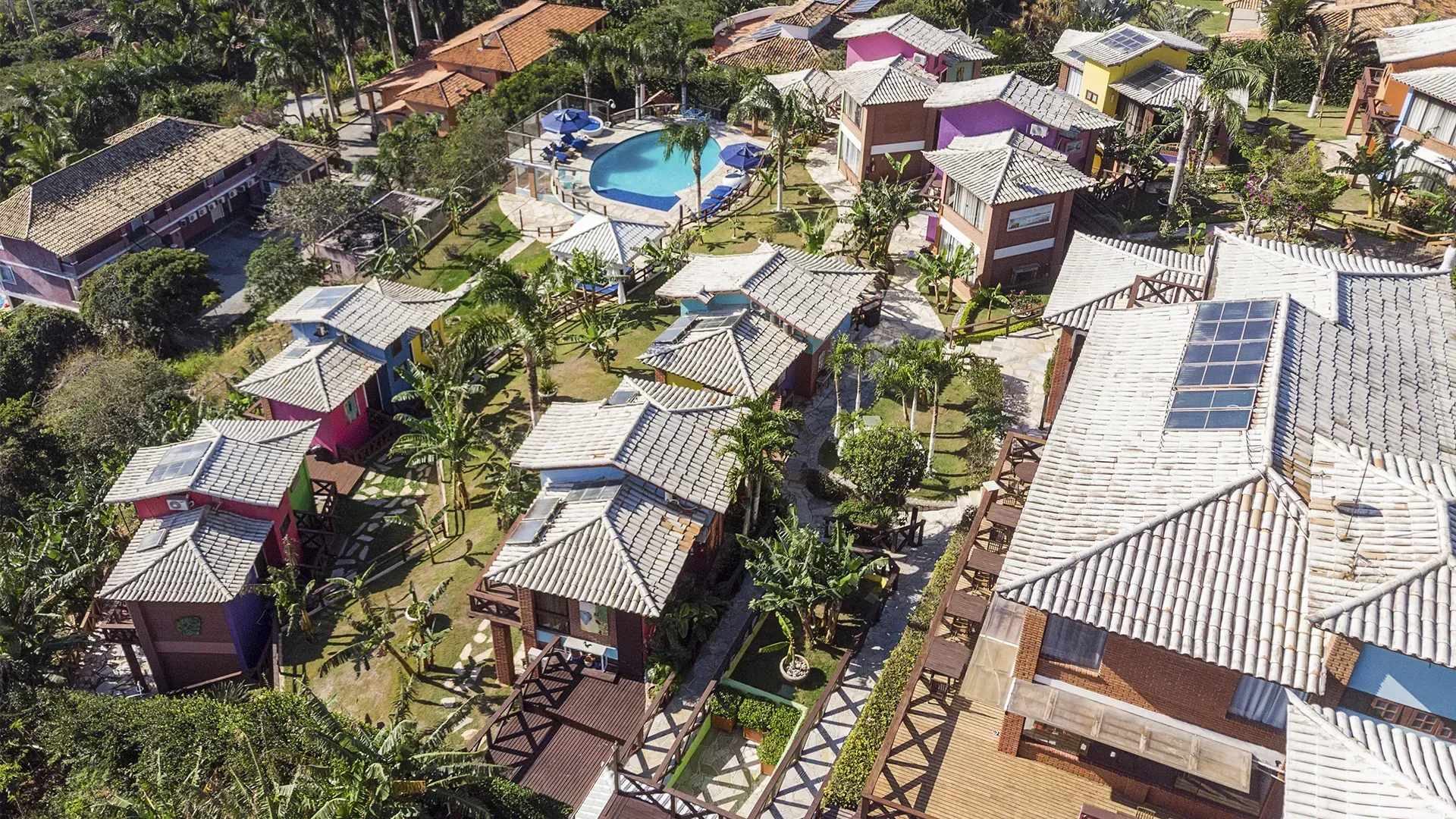 Uma vista aérea de uma área residencial com muitas casas e uma piscina.