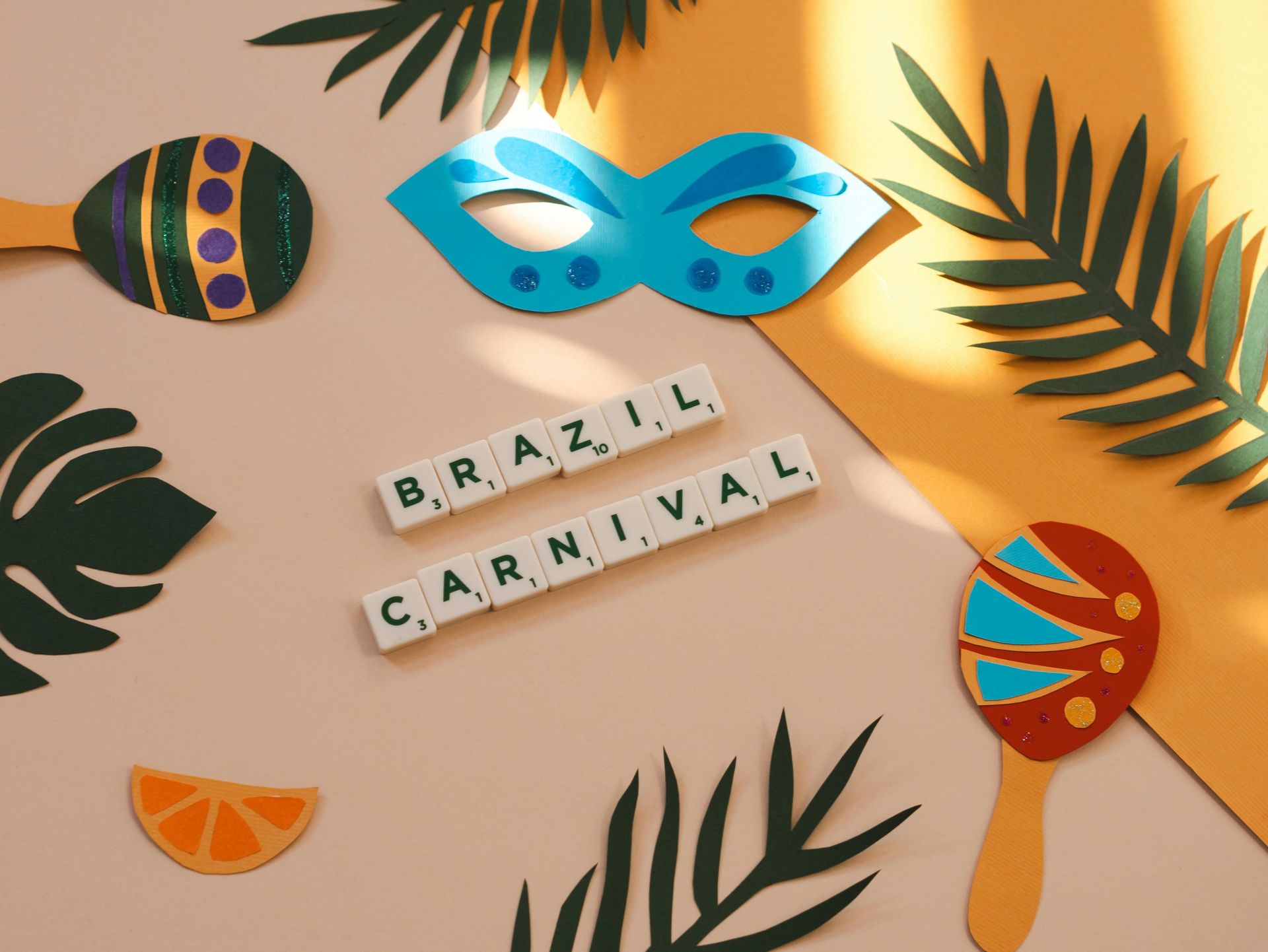 Natureza-morta com tema de Carnaval, contendo maracas, máscara, folhas de papel e a frase 
