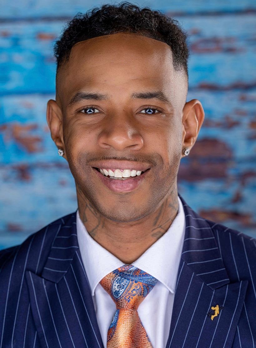 A man in a suit and tie is smiling for the camera.