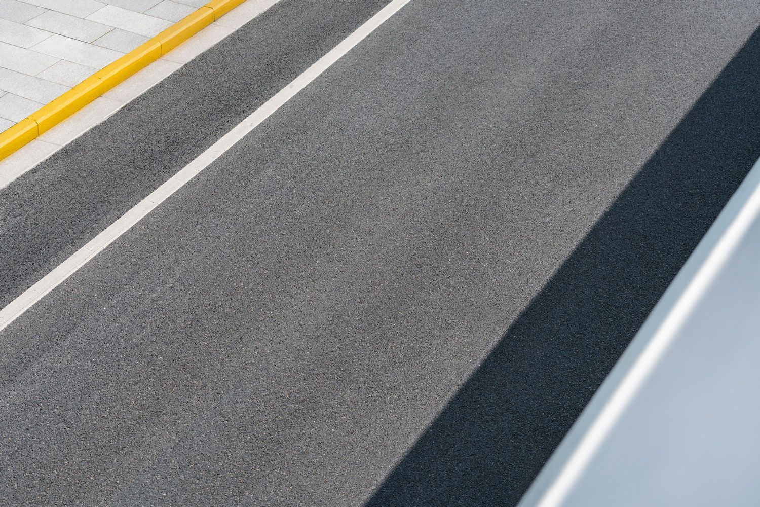 A Close Up Of A Road With A Yellow Curb — Murfreesboro, TN — Rocky Top Asphalt Paving  Inc.