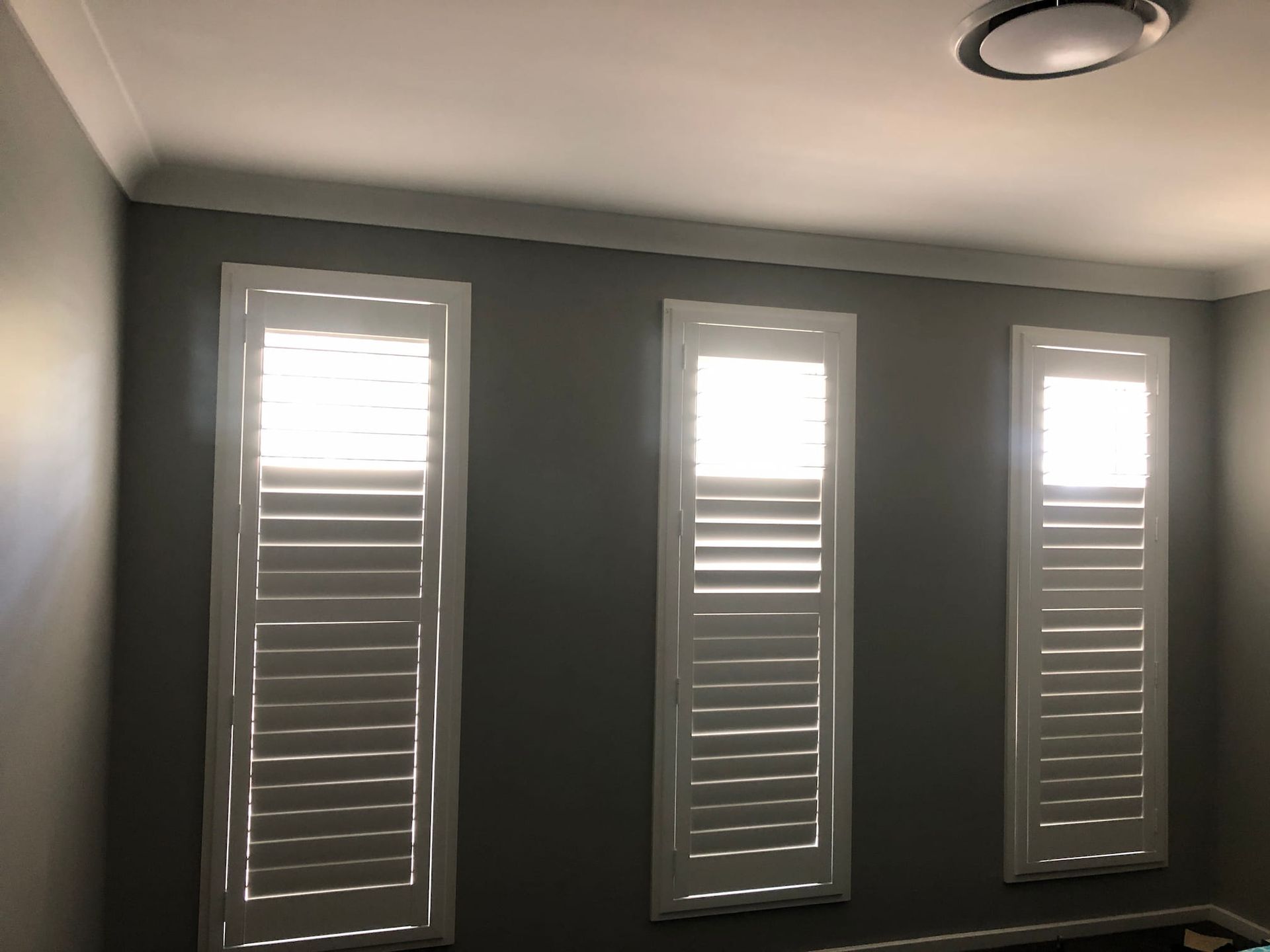 Three Plantation Shutter With The Dark Walls — Window Coverings in Exeter, NSW